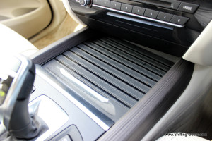 Storage bin below the centre console is neatly covered with a slider