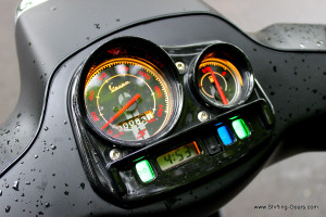 Instrument cluster gets gloss black plastic on top with a small wind deflector like design. Backlit in orange, this unit displays time, fuel gauge, speedometer and analogue odometer with a couple of tell-tale lights