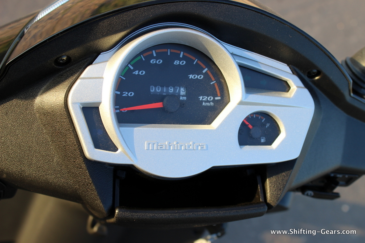 Silver coloured instrument cluster looks plain Jane. Notice the nifty storage spot below.